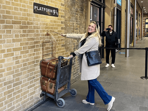 Tour member holding trolley at Platform 9 3/4