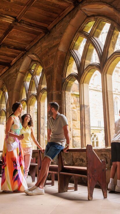 A family walking inside the cloisters of Durham Cathedral