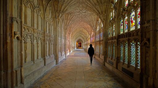 A person walking through the cloisters of Gloucester Cathedral