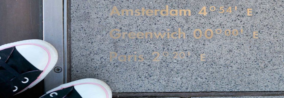 person standing next greenwich meridian line