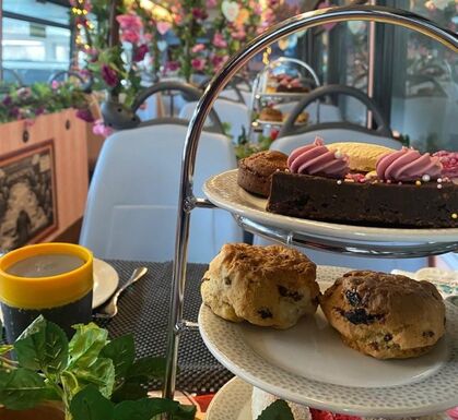 A delightful table showcasing three tiered trays brimming with a variety of tempting pastries and cakes.