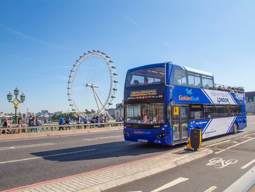 The Hop on hop off London Bus Tour at Westminster Bridge with the London Eye at the background