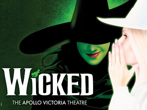 Glinda whispers something into The Wicked Witch of the West's ear in Wicked