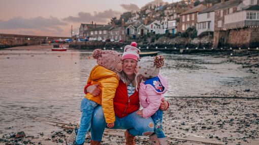 A mum with her two kids on the beach during winter