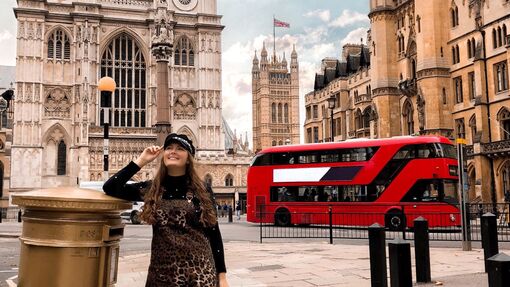 A red bus and a tourist outside Westminster Abbey