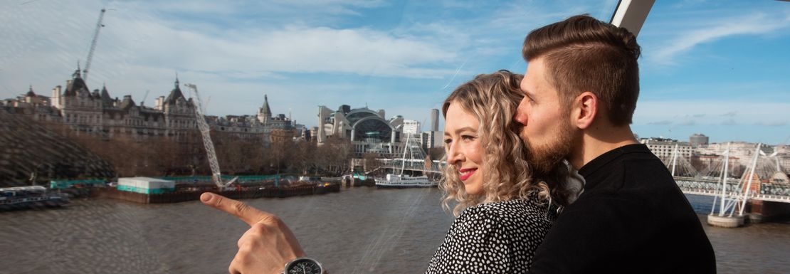 Couple embracing and enjoying city views from lastminute.com London Eye pod
