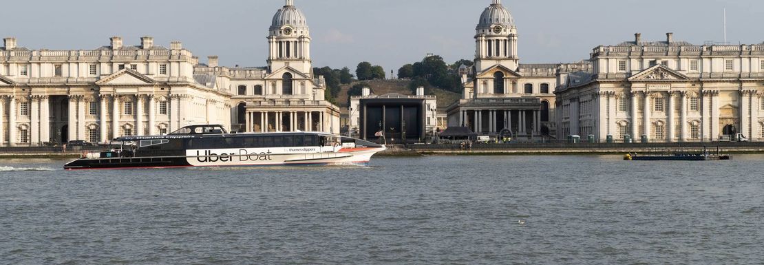 Uber Boat travels in front of the Old Royal Naval College on the Thames in London