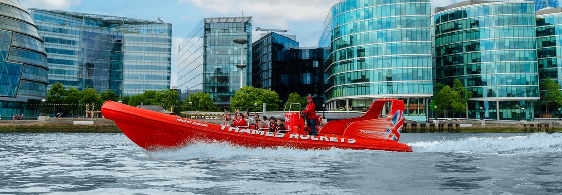 A Thames Rockets speedboat zooms past with London sights in the background