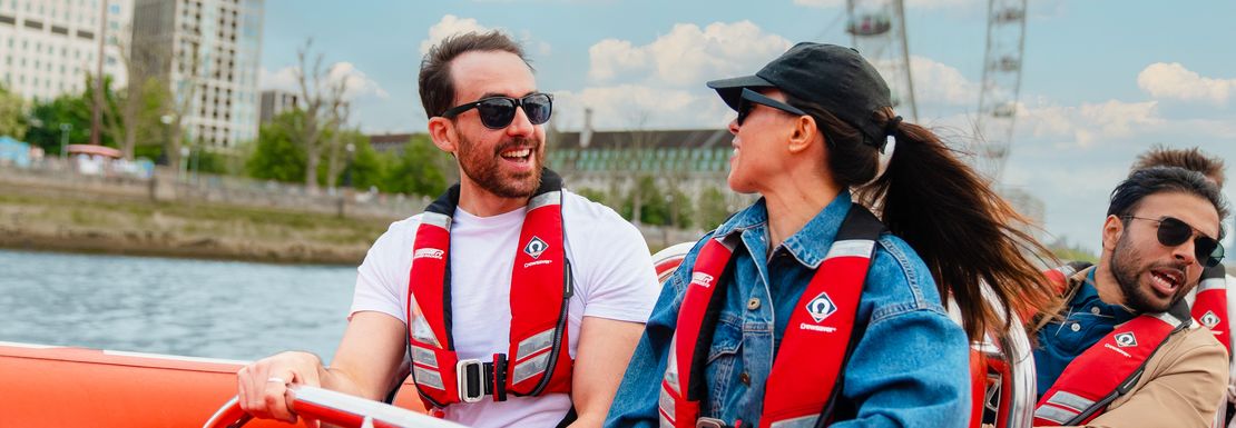 A mand and a woman enjoy the thames speedboat ride and have a chat together
