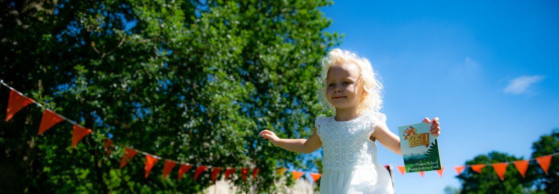A girl runs along at Warwick Castle in a white dress