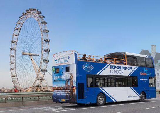 The Golden Tours double decker bus passes the London Eye in the distance